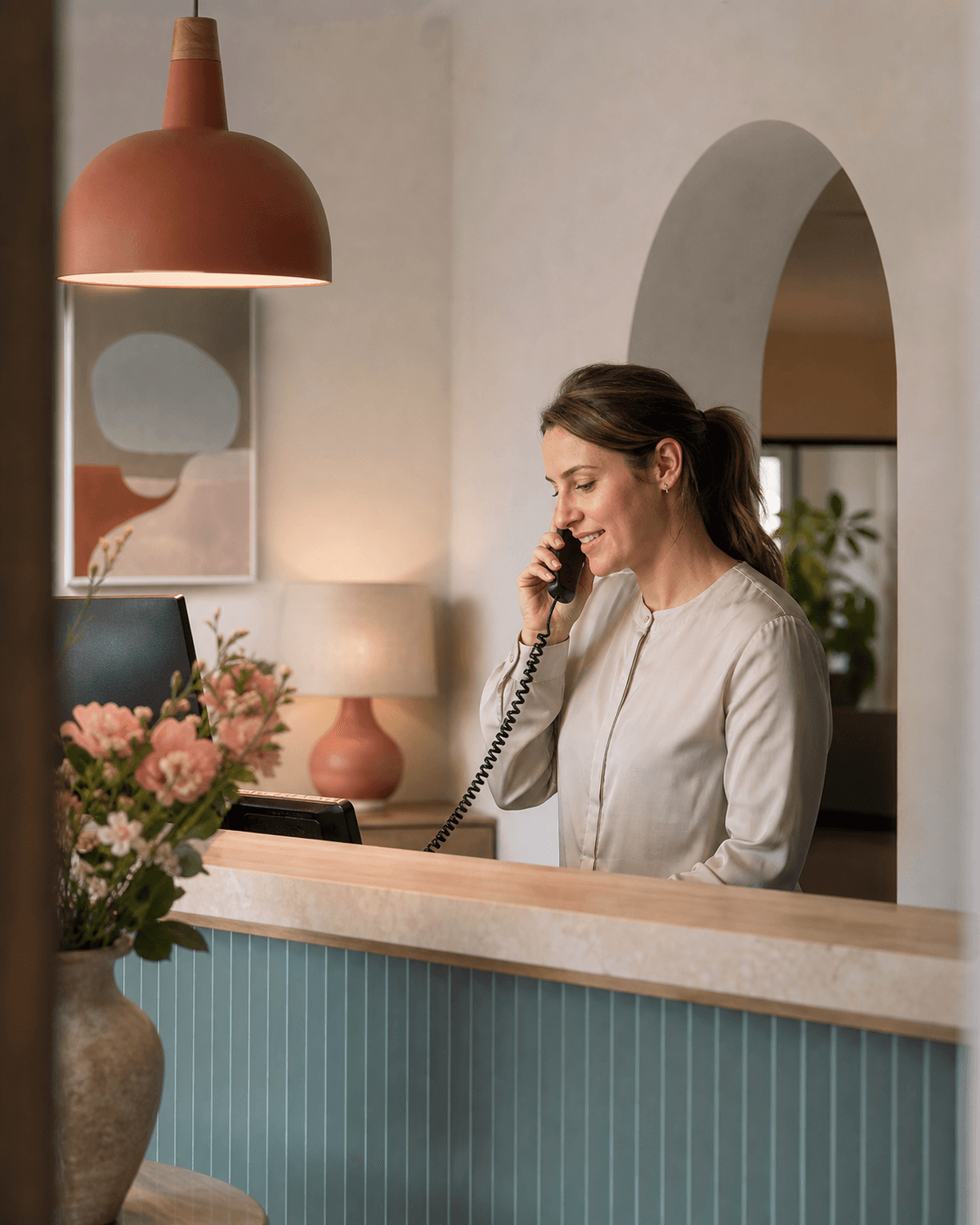 Eine Mitarbeiterin telefoniert am Empfang